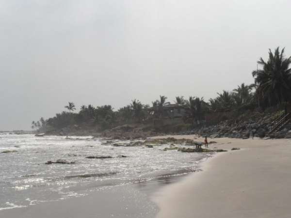 Strand von Krokobitey mit Brandung und Palmen im Wind